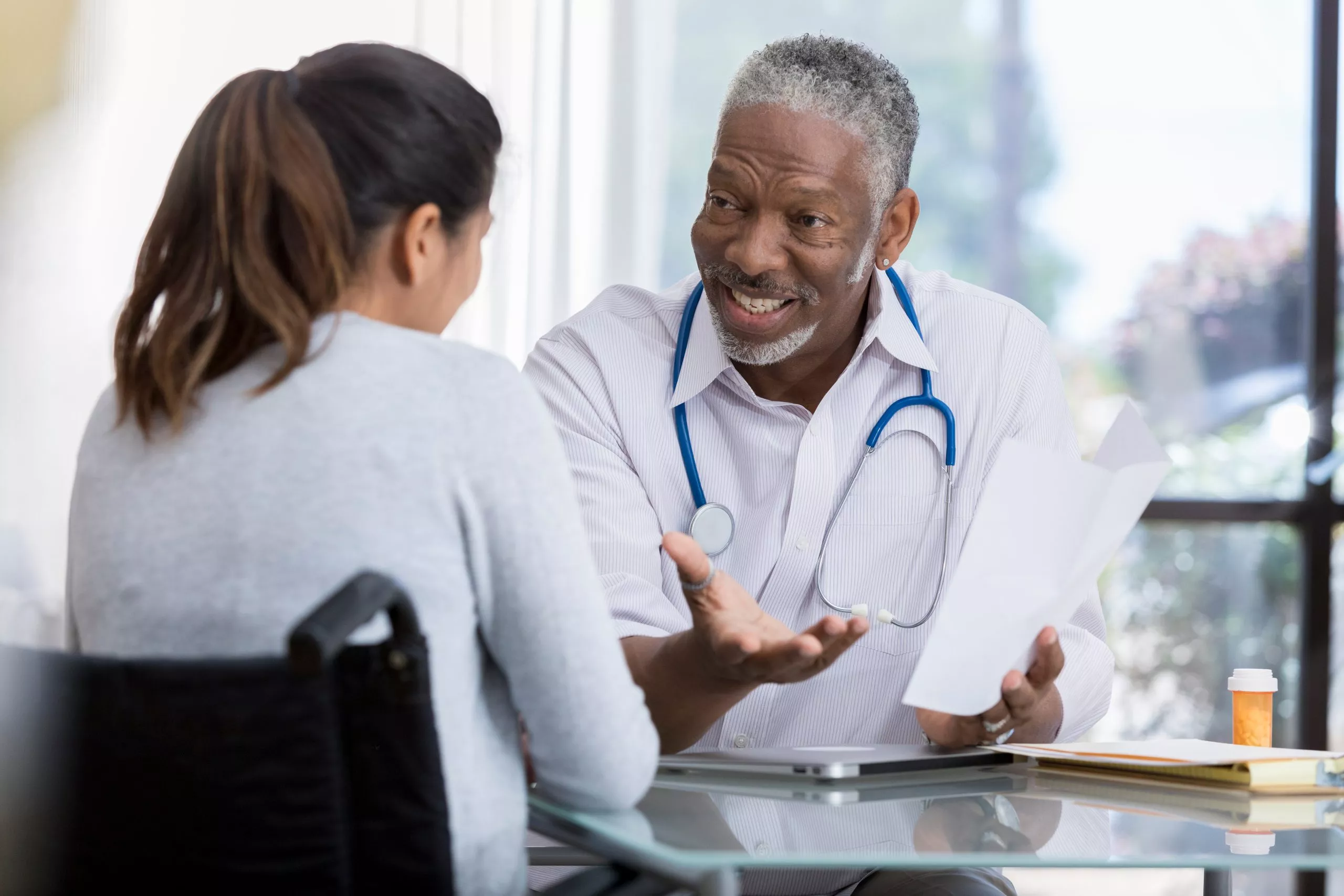 Senior doctor talks with female patient